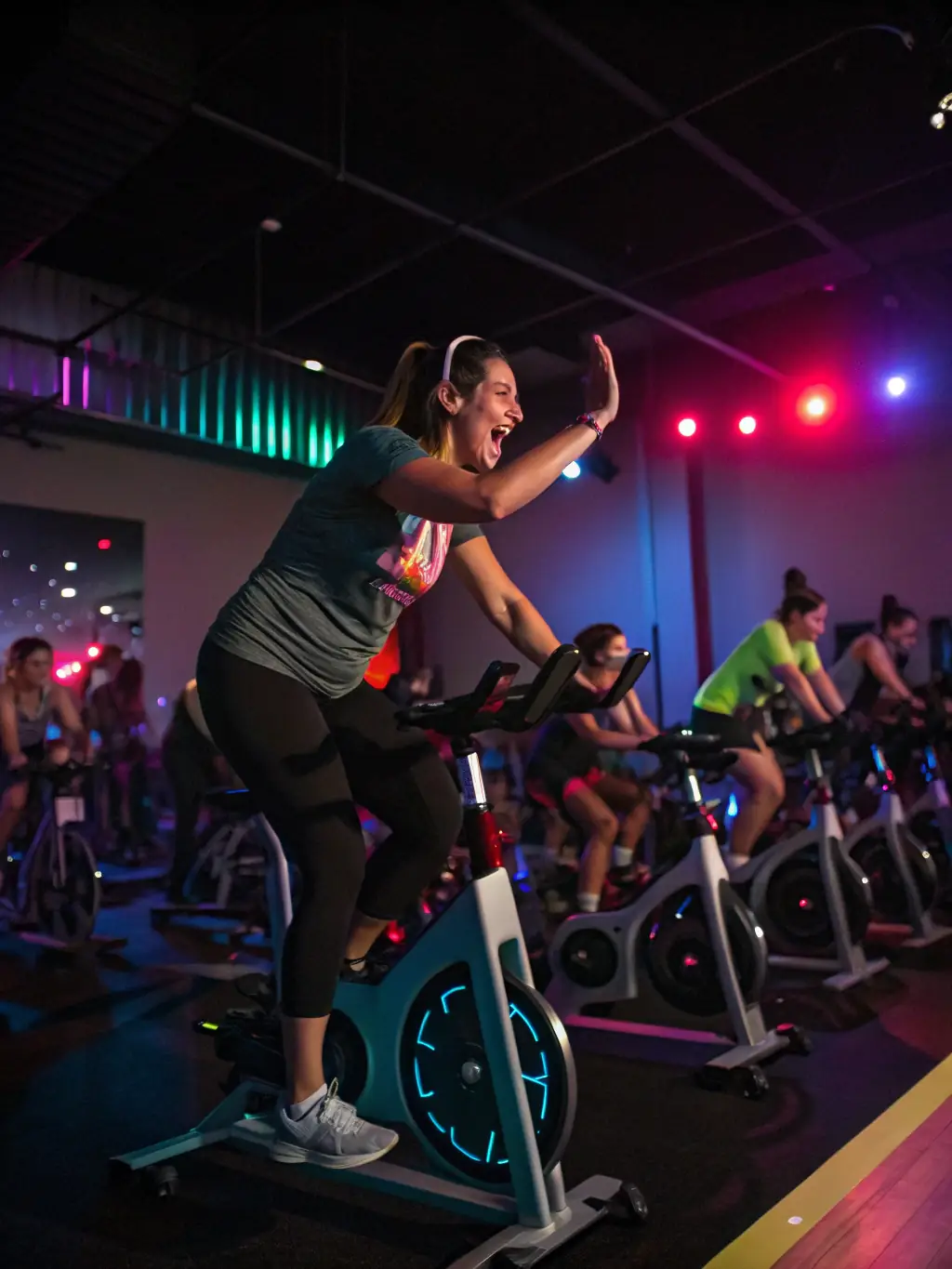 A spinning class at The Flow Fitness, with cyclists pedaling intensely to upbeat music, showcasing a high-energy workout.