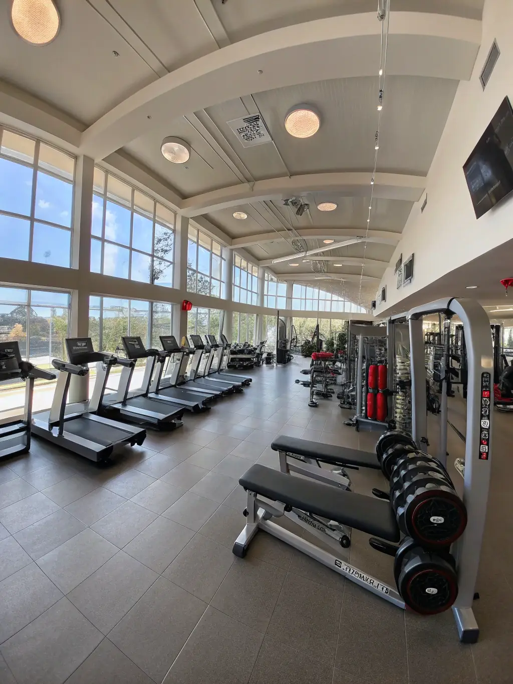A Smith machine and other weightlifting machines in a clean and organized gym environment.